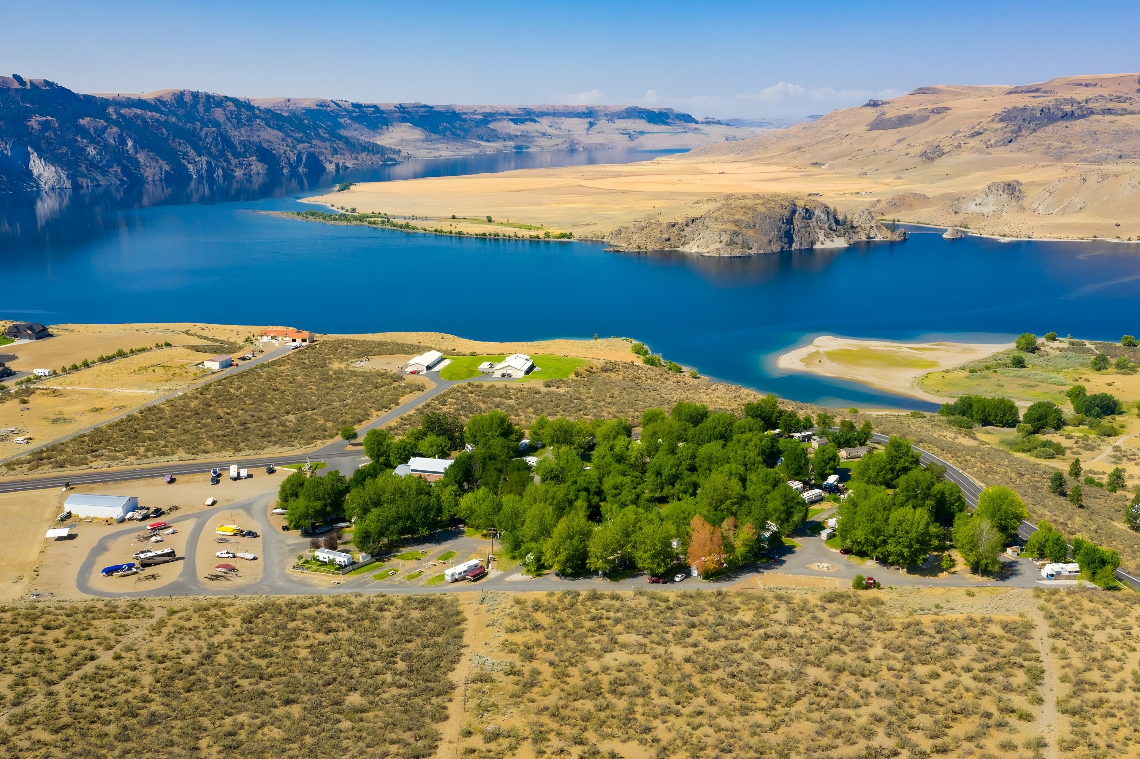Aerial view of the park's trees beside the blue water of Lake Roosevelt