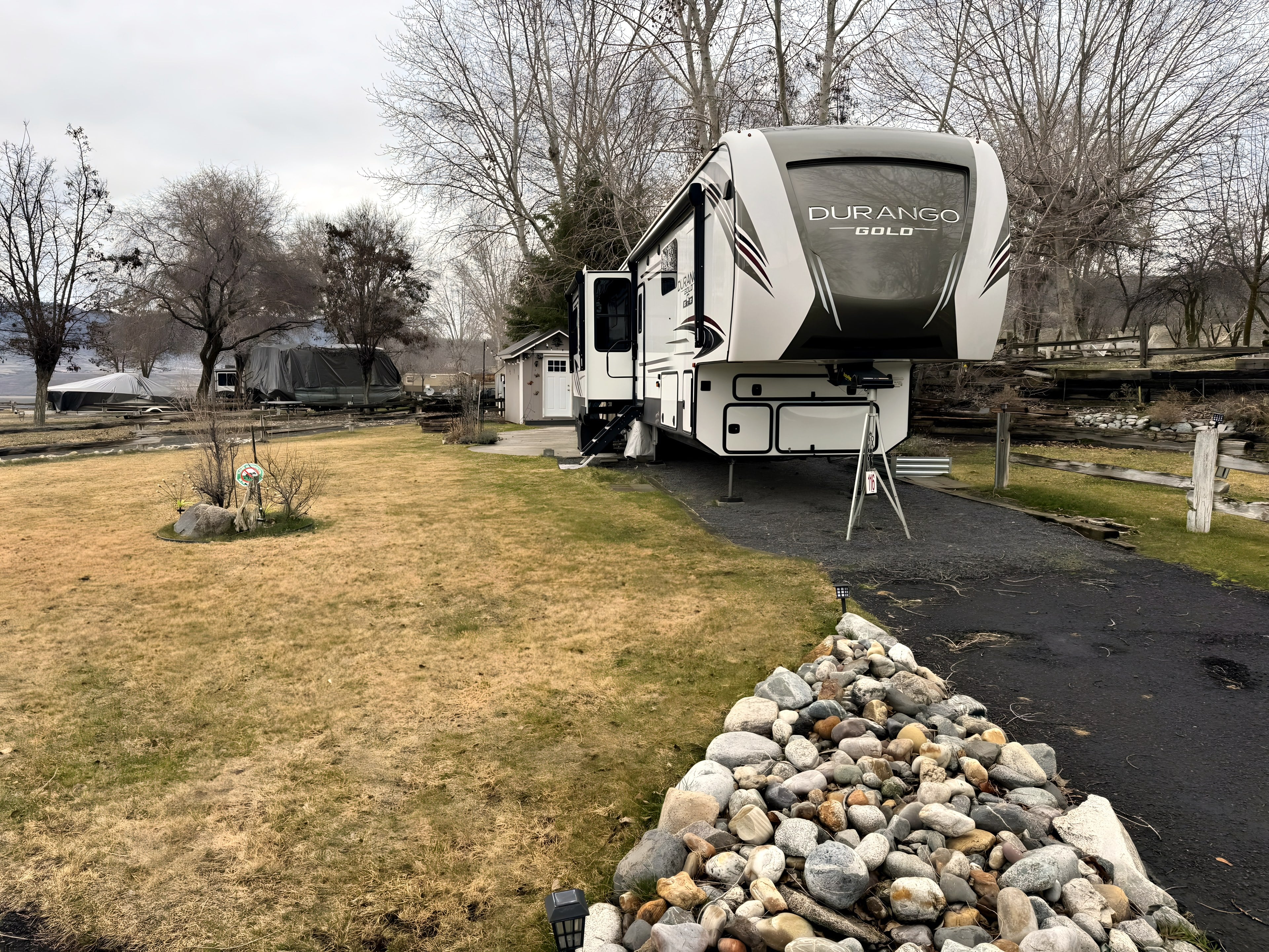 A fifth-wheel parked on a roomy paved site